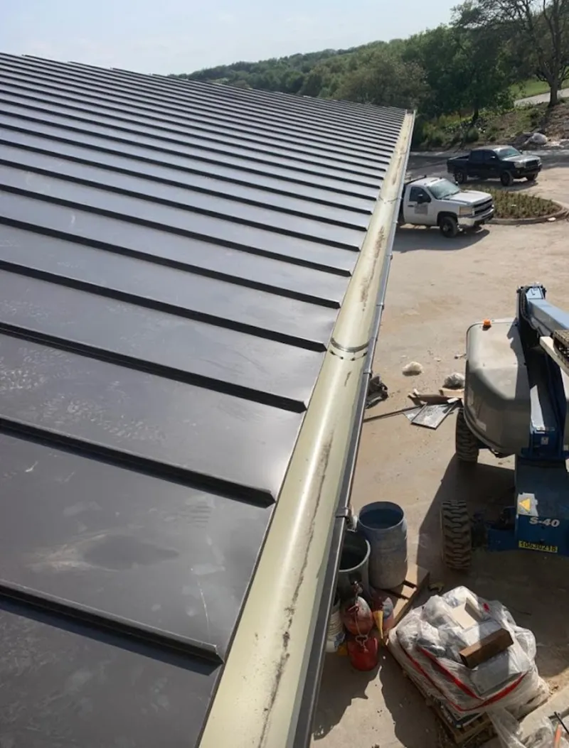 Standing seam panel and gutter detail on a metal roofing jobsite in Tenafly